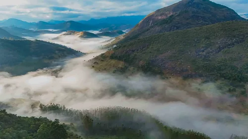 Vale de montanhas coberto por névoa ao amanhecer na Fazenda Baturité