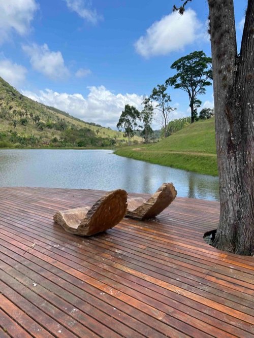 Deck de madeira com lago e montanhas ao fundo
